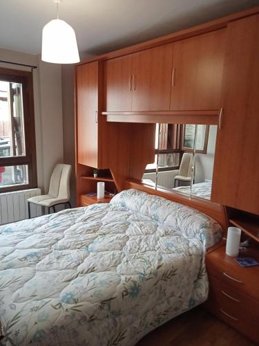 a bedroom with a large bed and a mirror at Apartamento CIR in Villanúa