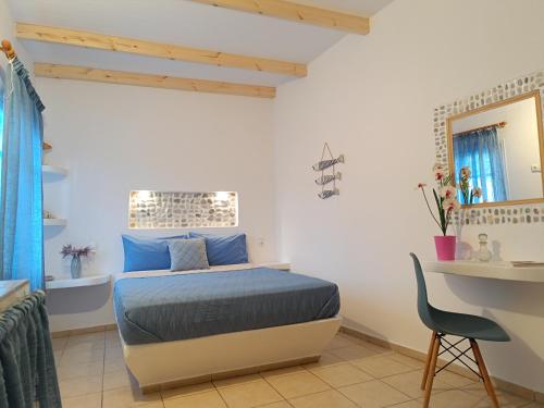 a bedroom with a bed and a desk and a chair at PERIVOLI 4-CHORA(5min away from the center by car) in Agkidia