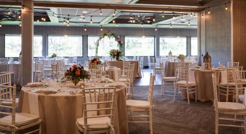 a room full of tables and chairs with white linens at Holiday Inn Milwaukee Riverfront by IHG in Milwaukee