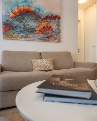a living room with a couch and a table with a laptop on it at Amare Luxury Apartments in Budva