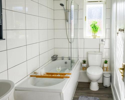 a white bathroom with a tub and a toilet at Stylish Two-bed House Birmingham sleep up-to 6 in Birmingham