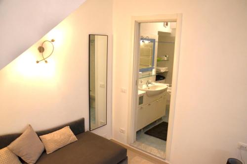 a bathroom with a couch and a sink and a mirror at Pae veciu camera privata con bagno in Monterosso al Mare