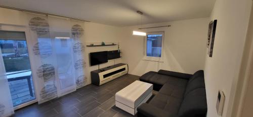 ein Wohnzimmer mit einem Sofa und einem TV in der Unterkunft Ferienhaus Sole in Velden am Wörthersee