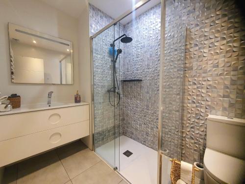 y baño con ducha acristalada y lavamanos. en EF7 Beds & Family, en Tarragona