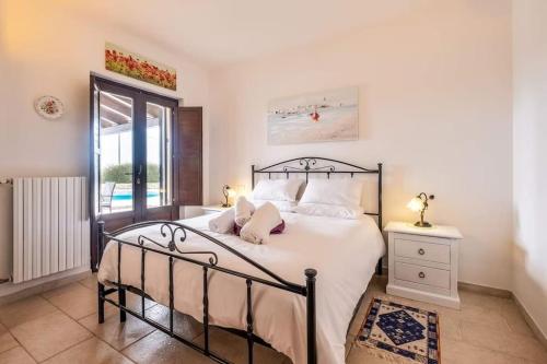 アルベロベッロにあるTrullo Olivia con piscina riscaldata, natura e relaxのベッドルーム(大きな白いベッド1台、窓付)