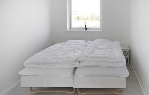 a white bed in a room with a window at Holiday Home Skovridervænget R Denmark in Spodsbjerg