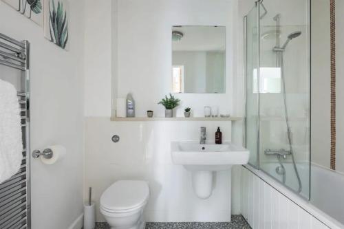 y baño con aseo, lavabo y ducha. en Luxury Milton Keynes Apartment at The Prevé en Milton Keynes