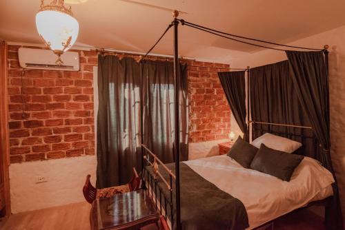 a bedroom with a canopy bed in a brick wall at Apartment in Antique Museum Filip in Bitola