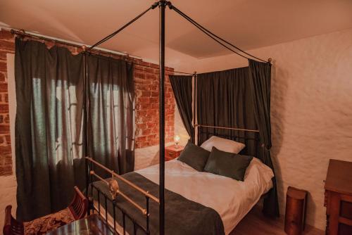 a bedroom with a four poster bed with black curtains at Apartment in Antique Museum Filip in Bitola