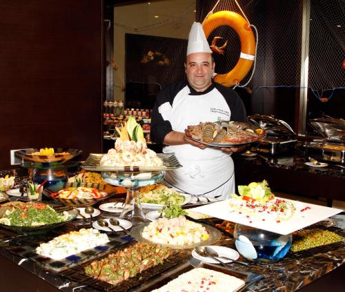 a chef standing in front of a buffet of food at Holiday Inn Tabuk by IHG in Tabuk