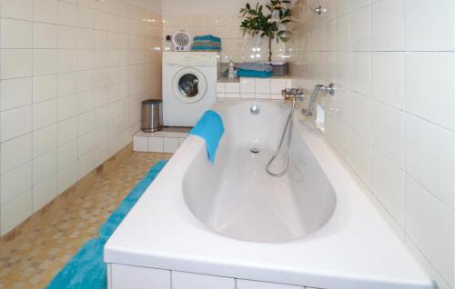 a bath tub in a bathroom with a washing machine at Ferienwohnung In Irschen in Irschen