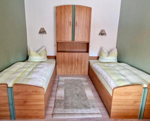 a room with two beds and a wooden cabinet at Fuchsbau in Schwedt