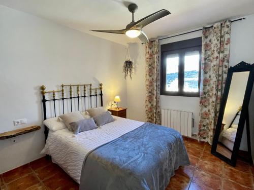 a bedroom with a bed and a ceiling fan at La casita del pueblo in Fondón