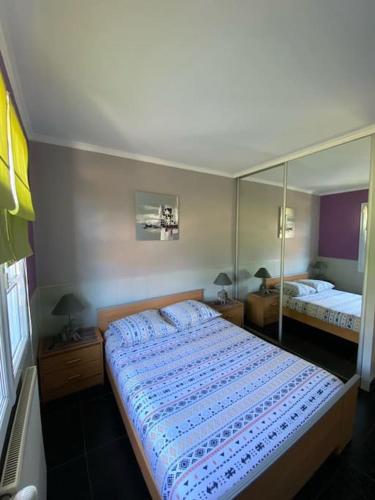 una camera da letto con un letto e un grande specchio di Maison chaleureuse aux portes de Tours. a Saint-Branchs