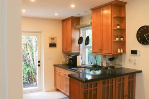 uma cozinha com armários de madeira e um balcão preto em Sunny 3 Bedroom 3 Bath Retreat in Fort Lauderdale em Fort Lauderdale