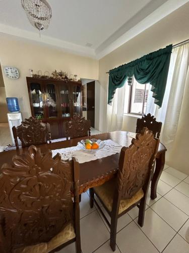 un comedor con mesa, sillas, mesa y sillón en Loidas place, en Talisay