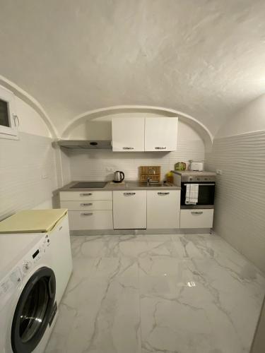 a kitchen with white cabinets and a washer at Luxury House Bergamo vicino aeroporto Orio e Ospedale Papa Giovanni XXIII in Curno