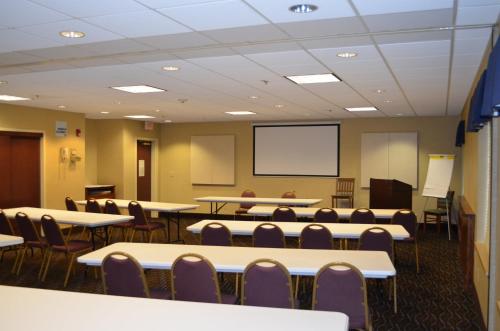 a classroom with tables and chairs and a projection screen at Holiday Inn Express Hotel & Suites Anniston/Oxford by IHG in Oxford