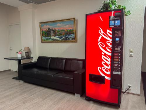 een coca cola automaat naast een bank bij Hostel Hermanni in Kuopio