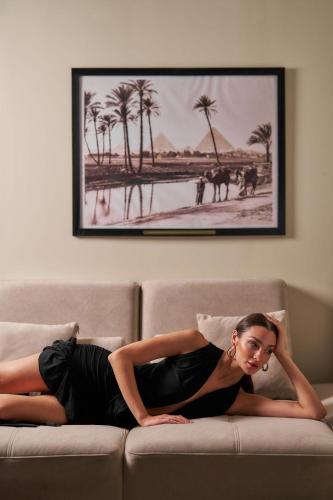 a woman in a dress laying on a couch at Pyra Hospitality West Pyramids Cairo in Cairo