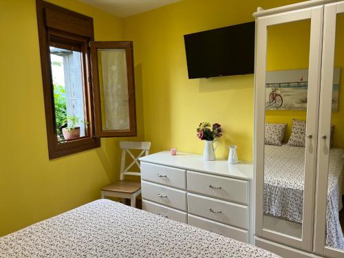 a bedroom with two beds and a dresser at Apartamento de Pascualin con jardin privado in A Coruña