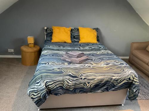 a bed with yellow pillows and a blanket on it at Glenashdale 28 A 1/R Boyd Street Largs KA308LE in Largs