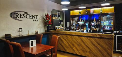 a bar with a wooden counter and a wooden table at The Osborne Hotel in Torquay