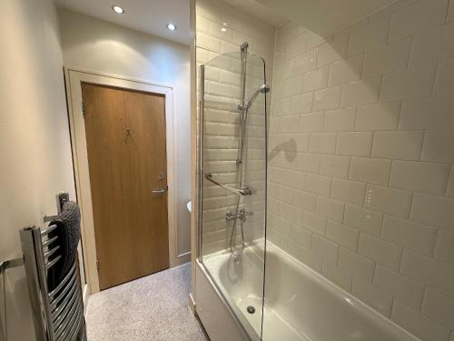 een badkamer met een douche en een glazen deur bij Apartment Thistle Lane in Edinburgh
