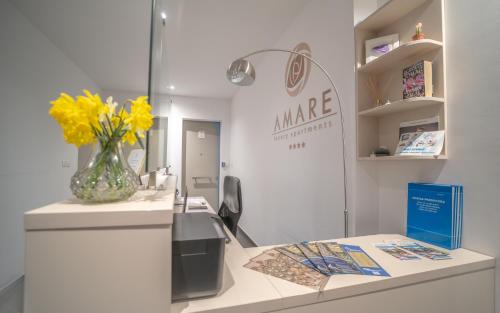 a counter with a vase with yellow flowers on it at Amare Luxury Apartments in Budva