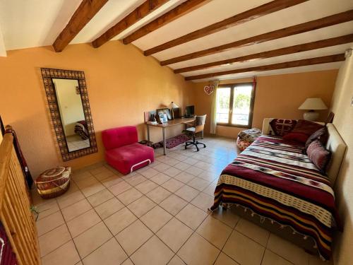 une chambre avec un lit, un miroir et une chaise dans l'établissement Maison indépendante pour des vacances en famille proche de la mer et de la montagne, à Saint-Estève