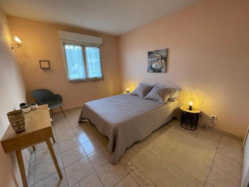 una camera con letto, tavolo e finestra di Grand T2 proche centre ville, vue mer et montagne a Bastia
