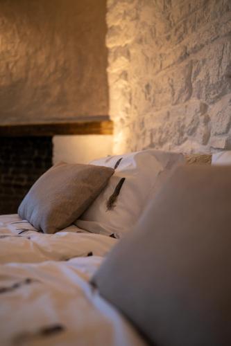 a bed with a pillow and a laptop on it at La ferme du Ravet - Gîtes aux Lacs de l'Eau d'Heure in Froid-Chapelle