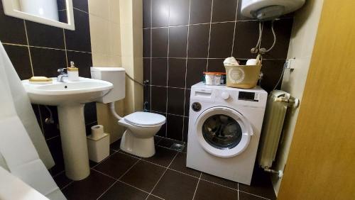 ein Badezimmer mit Toilette, Waschbecken und Waschmaschine in der Unterkunft Apartman Ady in Novi Pazar