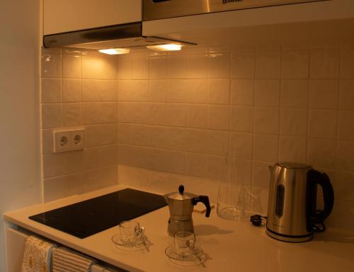 a kitchen counter with a tea kettle and glasses on it at Casa da Carvoaria in Vila Real