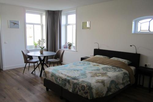 Schlafzimmer mit einem Bett, einem Tisch und Stühlen in der Unterkunft Aan de Dijk in Edam