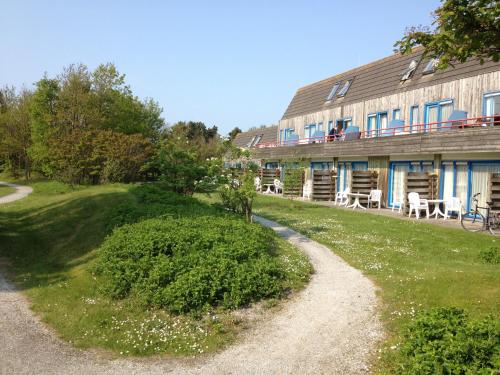 a house with a gravel road next to a building at Kaap 10 in Hollum