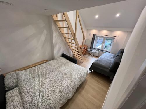 ein Wohnzimmer mit einem Bett und einer Treppe in der Unterkunft Duplex sympa Verviers in Verviers