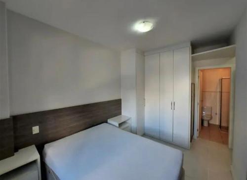 1 Schlafzimmer mit einem weißen Bett und einem Badezimmer in der Unterkunft Rap House in Nova Iguaçu
