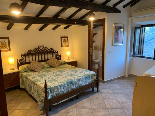a bedroom with a bed and two lamps and a bathroom at Il Carpino luxury historic apartment in Carpineto Romano