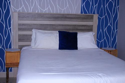 a bedroom with a bed with a blue wall at Lormasol Mews Guesthouse in Serowe