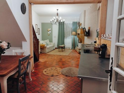 a kitchen and a living room with a table at Gite la Parent'aise in Bains-les-Bains