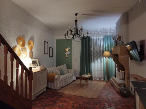 a living room with a couch and a chandelier at Gite la Parent'aise in Bains-les-Bains