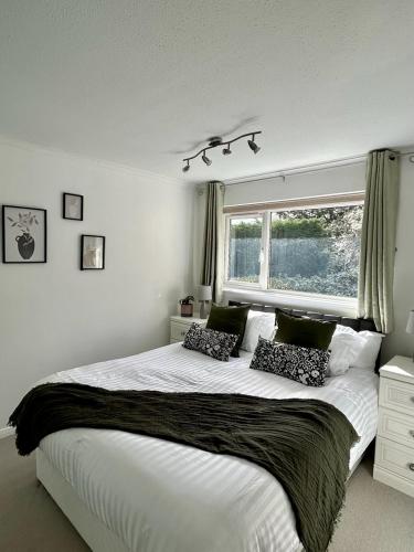 a bedroom with a large bed and a window at Stylish 3 Bed House Hitchin in Hitchin