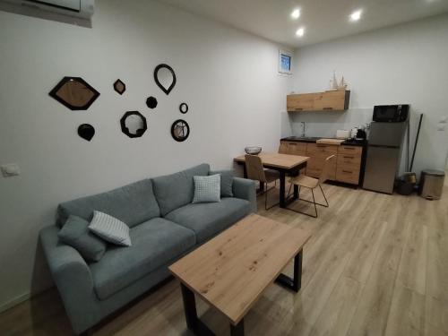 a living room with a blue couch and a table at Grand studio spacieux et climatisé in Saint-Raphaël