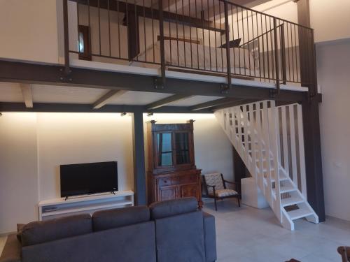 a living room with a loft with a staircase and a tv at Villetta Vittoria Country House. La depandance in Pennabilli