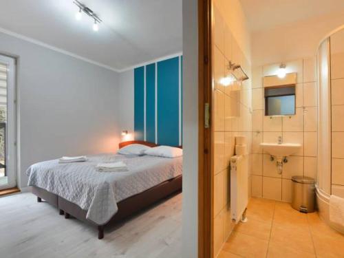 sypialnia z łóżkiem oraz łazienka z umywalką w obiekcie Ośrodek Wypoczynkowy Evita w mieście Krynica Zdrój