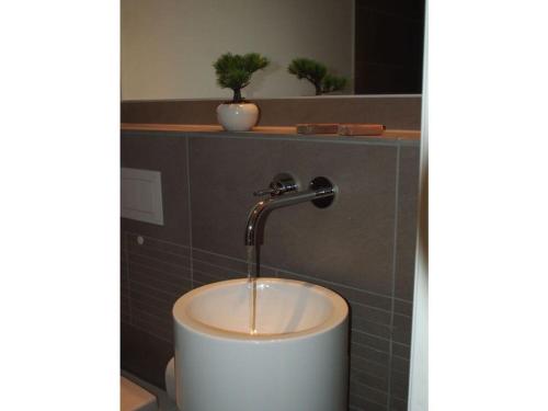 um lavatório numa casa de banho com uma torneira de água em Boothäuser Living_art Wangerooge em Wangerooge