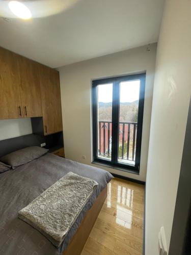 ein Schlafzimmer mit einem Bett und einem großen Fenster in der Unterkunft Jutarnja Zvezda Kop in Kopaonik