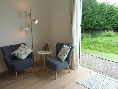 two chairs and a table in a room with a window at B&B BLoom in Amsterdam