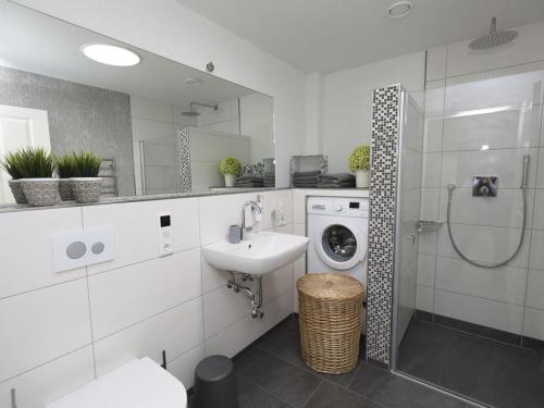 a bathroom with a sink and a washing machine at Holiday apartment Ponywiese in Ihlow